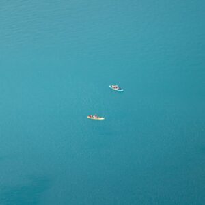 Lake Reflections - Aerial shot of two paddleboarders on the turquoi #19872373