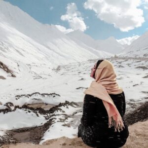 Snow Mountains - A woman sits on a snowy mountain, wrapped in a s #2664046