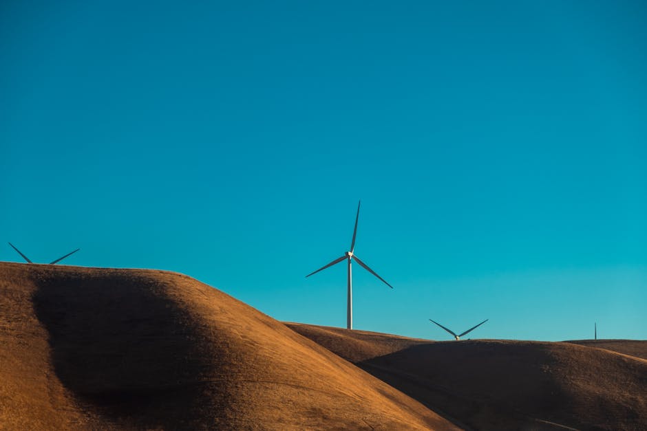 Desert Wilderness - Wind turbines on sandy dunes under a clear blue #5095830