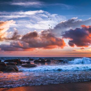 Beach Scenery - Captivating sunset over rocky ocean shore with d #6026414